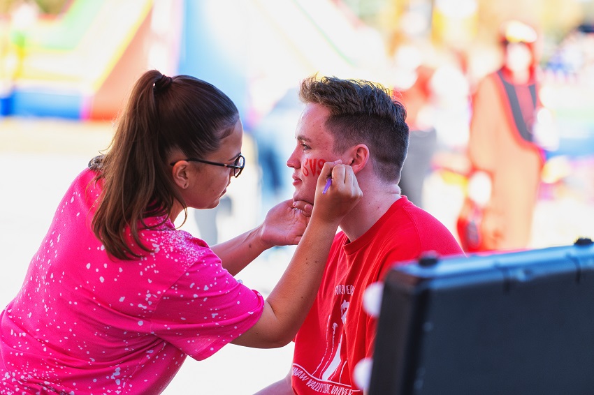 2024 Homecoming photo of alumni getting their face painted with SVSU while at the Alumni Tailgate